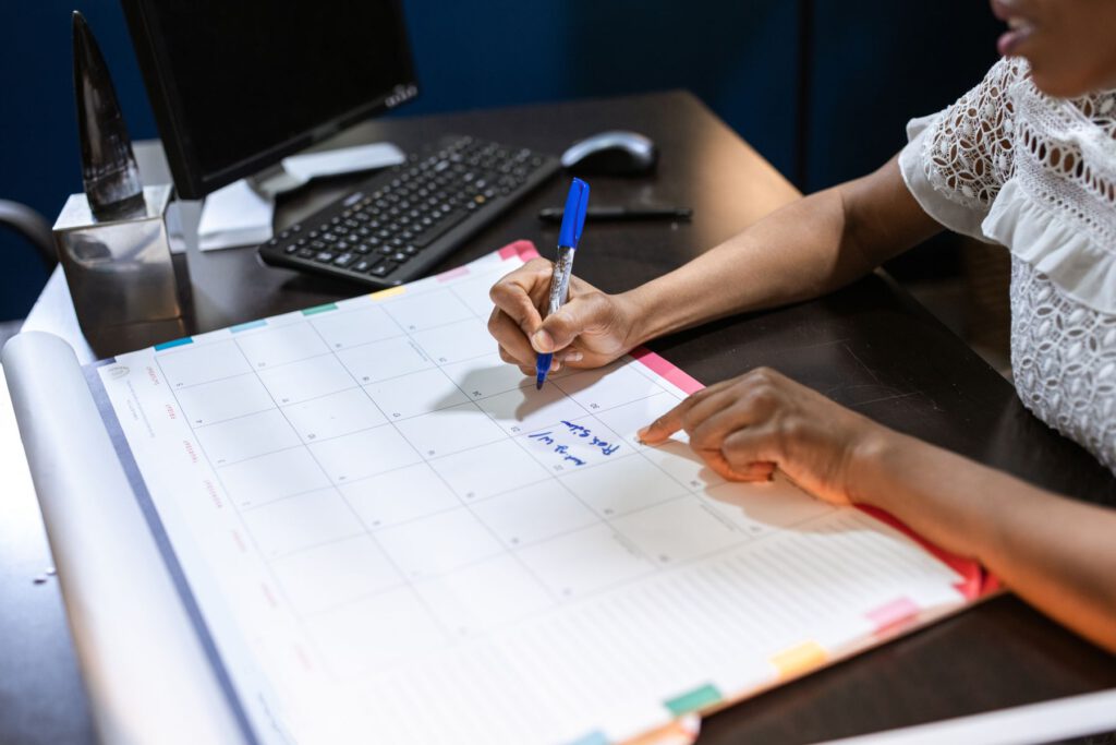 Iemand schrijft afspraken in een grote planner