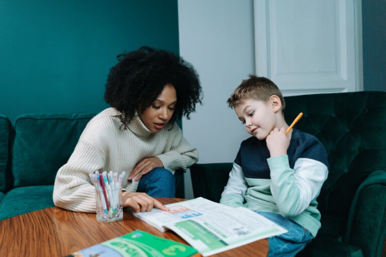 Een begeleider helpt een jongen met zijn huiswerk
